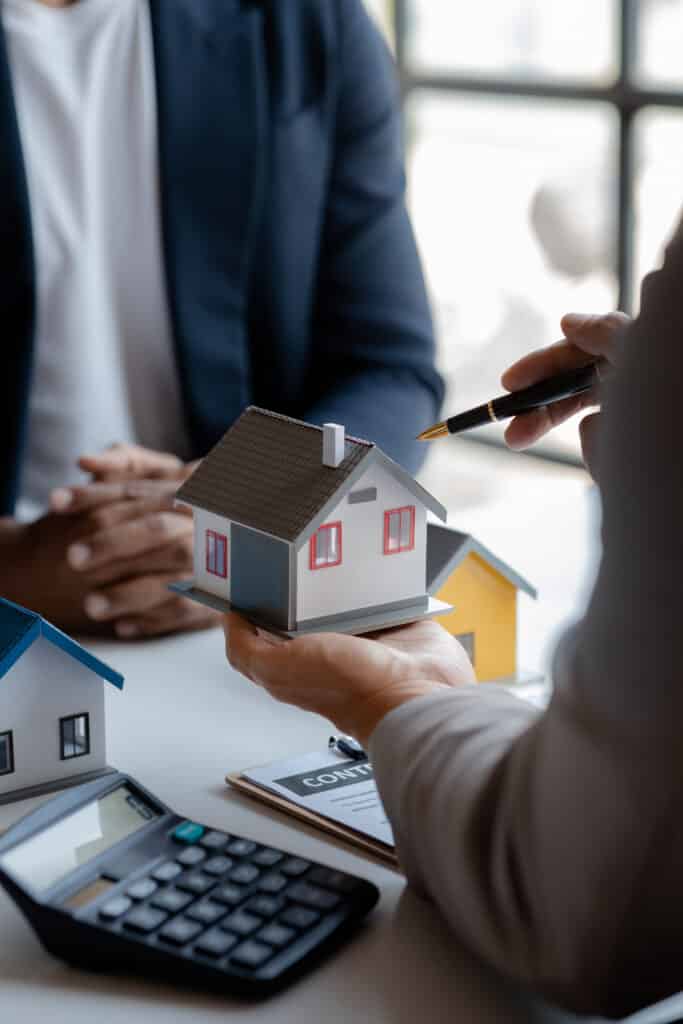 Real estate agents explain models of housing estates in projects to elaborate to clients, explaining and presenting information about homes and purchasing loans. Real estate trading concept.